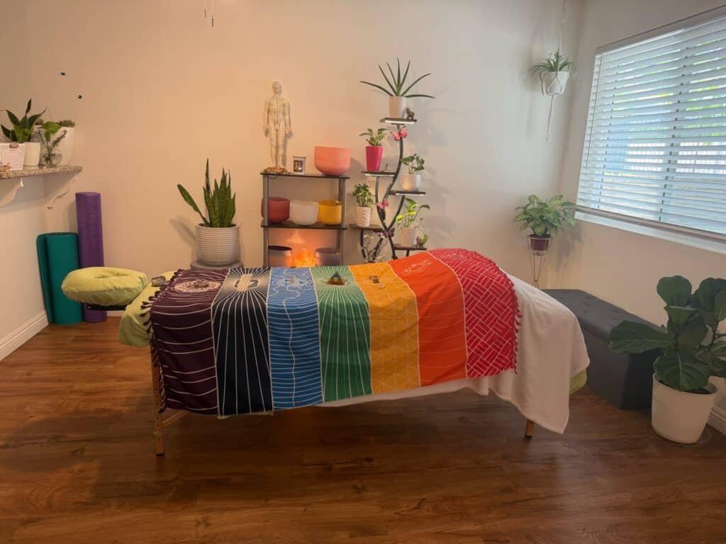 Relaxing massage therapy room with colorful blanket and plants.