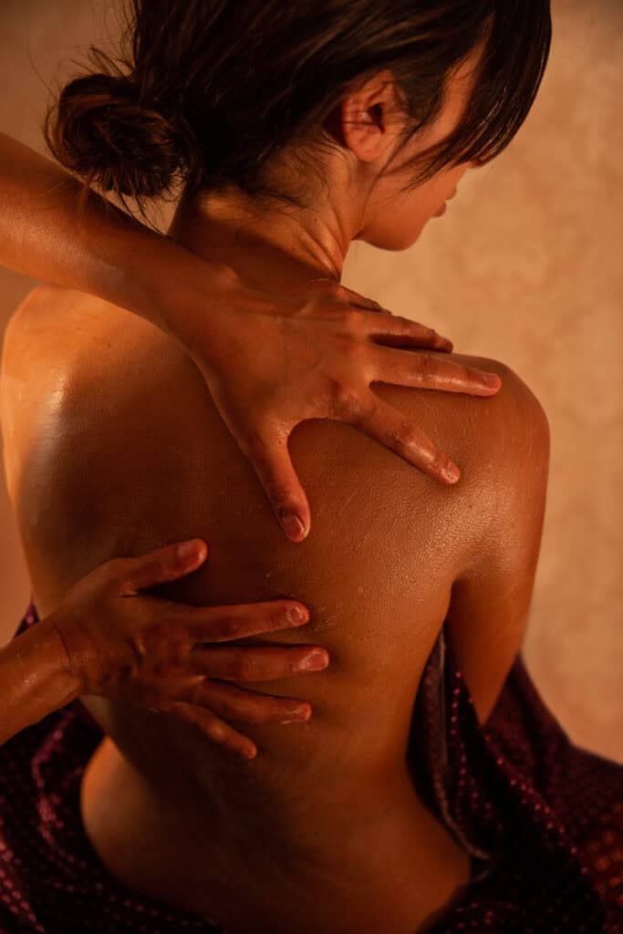 Woman receiving a professional back massage at Armonía Natural Massage Therapy.