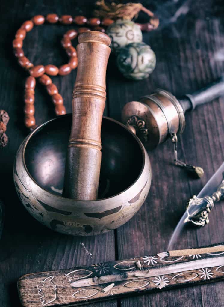 Healing sound bowl with wooden mallet and meditation accessories.