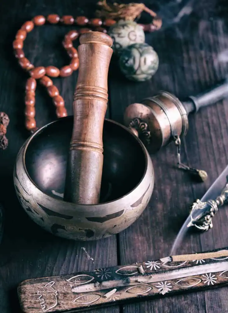 Healing sound bowl with wooden mallet and meditation accessories.