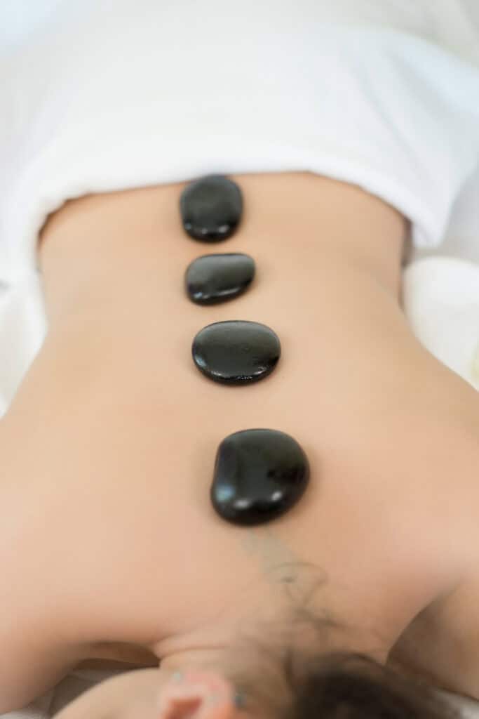 Hot stones placed along the back for massage therapy treatment.